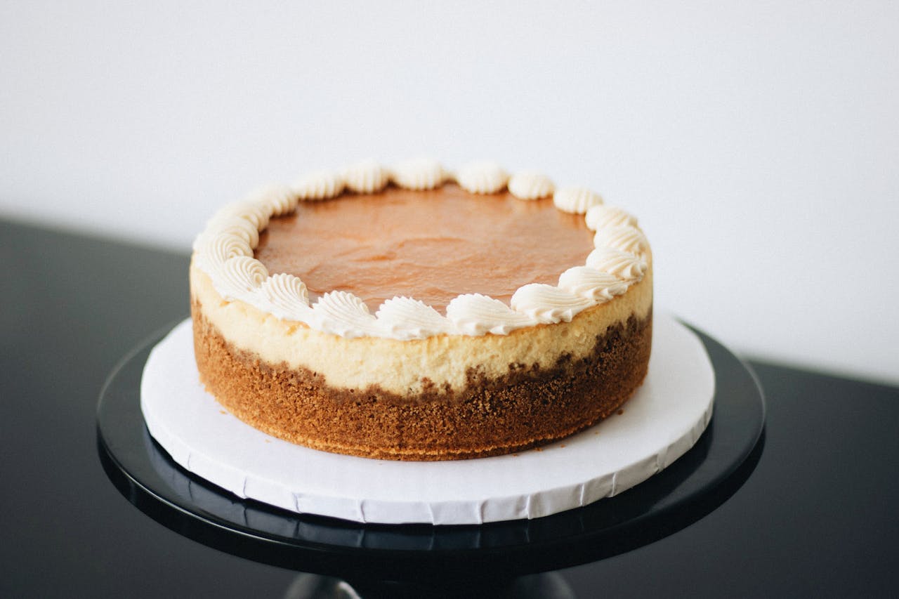 Home Elegant cheesecake with whipped topping, showcasing artisanal baking skills.